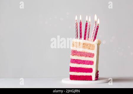 Fetta di torta rosa di compleanno ombre con sei candele rosa di compleanno per festeggiare un compleanno Foto Stock