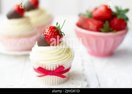 Fragole e cupcake alla crema serviti con fragole fresche ricoperte di cioccolato Foto Stock