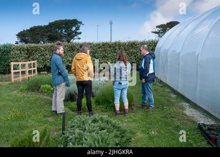 Un volontario Newquay Orchard che parla con un gruppo di persone nella comunità che cresce lo spazio in Newquay Orchard. Newquay Orchard è uno spazio creato Foto Stock