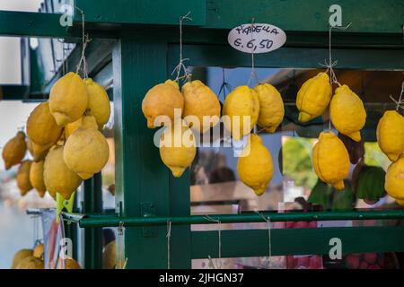 Limoni freschi appesi su corde per la vendita a Sirmione, Italia Foto Stock