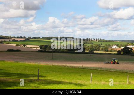 Un trattore lavora la terra in un'azienda agricola Foto Stock