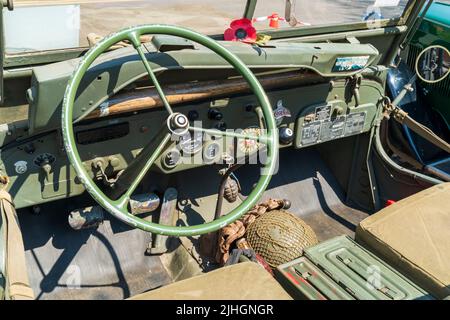 Il cruscotto di una classica guerra mondiale due esercito americano jeep. Ruota e indicatori di sterzata, con una granata appesa al cruscotto principale. Foto Stock