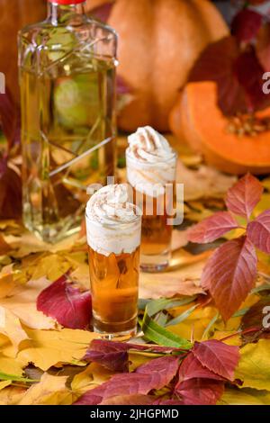 Due vodka con torta di zucca crema alla cannella spara in bicchieri da shot. Queste bevande sono facili da preparare e perfette per l'autunno. Prova queste bevande boozy al tuo Foto Stock