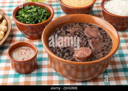 Tipica feijoada brasiliana con riso, caipirinha, farofa e cracklings. Foto Stock