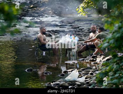 La gente gode di un barbecue in un fiume vicino al villaggio di Luss in Argyll e Bute, Scozia, sulla riva occidentale del Loch Lomond. Data foto: Lunedì 18 luglio 2022. Foto Stock