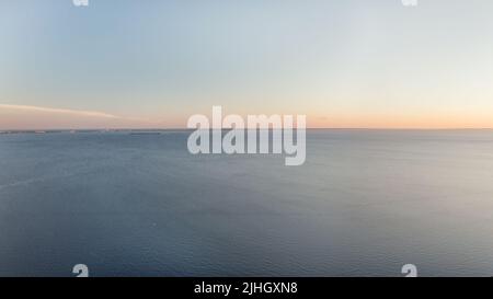 Orizzonte sul mare sparse minimalista seascape. Mare blu calmo e cielo limpido al tramonto grande vista aerea panoramica Foto Stock