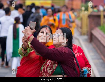 Kathmandu, Nepal. 18th luglio 2022. Le donne anziane prendono un selfie dopo aver visitato il tempio durante il festival di Shrawan Brata a Kathmandu. Durante il mese di Shrawan, ogni Lunedi le donne indù nepalesi adorano Lord Shiva per una lunga e prospera vita per il loro marito o per ottenere una buona. Credit: SOPA Images Limited/Alamy Live News Foto Stock