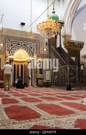 I visitatori musulmani pregano nella moschea di Abramo di Hebron. Qui si trovano le tombe di Isaac e Rebecca Foto Stock