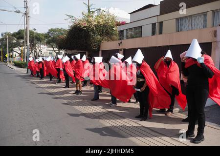 Lima, Perù, 18/07/2022, madri, vittime di violenza domestica o economica, transpersone, migranti, E tutti i tipi di donne e di diversità che indossano il coif bianco e il mantello rosso svolgono la performance di strada 'la racconto di Handsmaid' per attirare l'attenzione di Michelle Bachelet, l'Alto Commissariato delle Nazioni Unite per i diritti umani che si trova a Lima. Foto Stock