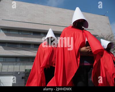 Lima, Perù, 18/07/2022, madri, vittime di violenza domestica o economica, transpersone, migranti, E tutti i tipi di donne e di diversità che indossano il coif bianco e il mantello rosso svolgono la performance di strada 'la racconto di Handsmaid' per attirare l'attenzione di Michelle Bachelet, l'Alto Commissariato delle Nazioni Unite per i diritti umani che si trova a Lima. Foto Stock