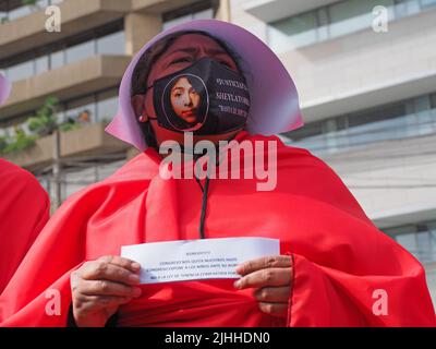 Lima, Perù, 18/07/2022, madri, vittime di violenza domestica o economica, transpersone, migranti, E tutti i tipi di donne e di diversità che indossano il coif bianco e il mantello rosso svolgono la performance di strada 'la racconto di Handsmaid' per attirare l'attenzione di Michelle Bachelet, l'Alto Commissariato delle Nazioni Unite per i diritti umani che si trova a Lima. Foto Stock