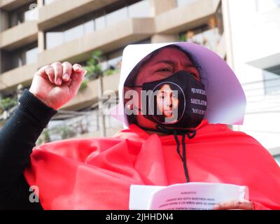 Lima, Perù, 18/07/2022, 'Aiuto! Il Congresso ci allontana i nostri figli, il Congresso espone i bambini al loro aggressore. Non alla legge sulla custodia congiunta forzata» può essere letta in un foglio di carta quando madri, vittime di violenza domestica o economica, trasgressioni, migranti, E tutti i tipi di donne e di diversità che indossano il coif bianco e il mantello rosso svolgono la performance di strada 'la racconto di Handsmaid' per attirare l'attenzione di Michelle Bachelet, l'Alto Commissariato delle Nazioni Unite per i diritti umani che si trova a Lima. Foto Stock