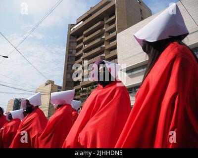 Lima, Perù, 18/07/2022, madri, vittime di violenza domestica o economica, transpersone, migranti, E tutti i tipi di donne e di diversità che indossano il coif bianco e il mantello rosso svolgono la performance di strada 'la racconto di Handsmaid' per attirare l'attenzione di Michelle Bachelet, l'Alto Commissariato delle Nazioni Unite per i diritti umani che si trova a Lima. Foto Stock