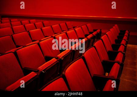 auditorium rosso brillante con file di sedili coperti di tessuto rosso vuoto Foto Stock