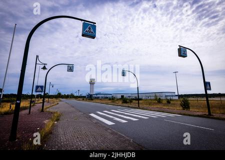 Parchim, Germania. 18th luglio 2022. La torre di controllo del traffico aereo e l'edificio del terminal si trovano sul sito a cordoni dell'ex aeroporto. Dopo essere stato acquistato da un investitore cinese, l'ex aeroporto militare dell'esercito russo doveva essere sviluppato in un centro di volo internazionale del carico. Dopo l'insolvenza dell'operatore nel maggio 2019, le operazioni di volo sono cessate e gli impianti all'aperto sono parzialmente sopravallevati. Credit: Jens Büttner/dpa/Alamy Live News Foto Stock