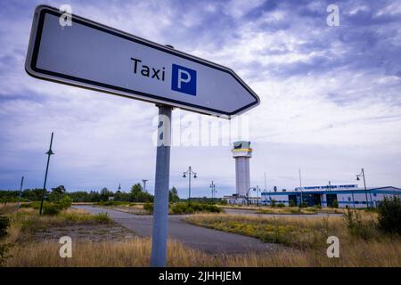 Parchim, Germania. 18th luglio 2022. Un cartello per i taxi si trova nello spazioso parcheggio di fronte all'edificio del terminal dell'ex aeroporto. Dopo essere stato acquistato da un investitore cinese, l'ex aeroporto militare dell'esercito russo doveva essere sviluppato in un centro di volo internazionale del carico. Dopo l'insolvenza dell'operatore nel maggio 2019, le operazioni di volo sono cessate e gli impianti all'aperto sono parzialmente sopravallevati. Credit: Jens Büttner/dpa/Alamy Live News Foto Stock