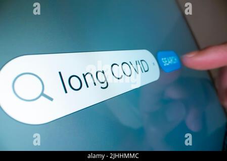 Vista ravvicinata della ricerca di informazioni su Long COVID su Internet Foto Stock