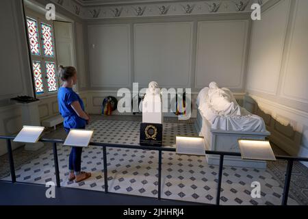 12 luglio 2022, Meclemburgo-Pomerania occidentale, Hohenzieritz: Christine Henning, Museum Education, si trova nella camera della morte della Regina Luise di Prussia (1776-1810) nel palazzo vicino al 'segmento busto della Tomba Figura della Regina Luise' (c. 1820 - 1830) di Christian Daniel Rauch. Sulla destra si trova la "grave figura della regina Luise di Prussia" (gesso in gesso della copia di marmo di Neustrelitz). Il busto originale è stato ora restituito al memoriale. Il busto sarà presentato a Hohenzieritz il giorno di Luise (19.07.2022) in occasione del 212th° anniversario della morte dell'un tempo amato Foto Stock