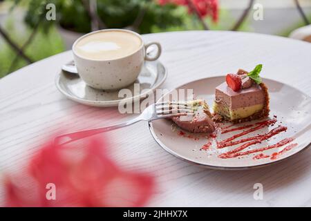 Soufflé di cashew naturale senza farina, latte e cottura e tazza di cappuccino su tavola di legno all'aperto nella terrazza del caffè. Pausa caffè Foto Stock