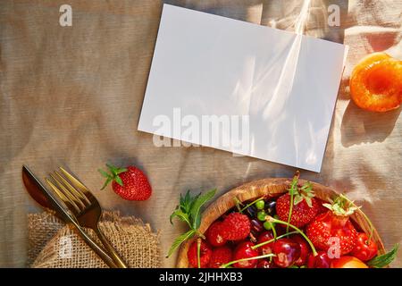 Carta di cancelleria stagionale brillante estate con ombre, luce del sole, frutta fresca e frutti di bosco. Vista dall'alto, spazio di copia. Foto Stock