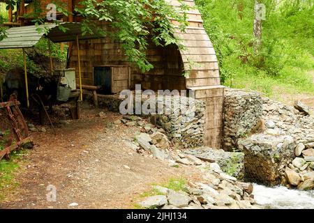 Vecchia piccola centrale idroelettrica manuale su un piccolo ruscello. Background di generazione di energia Foto Stock