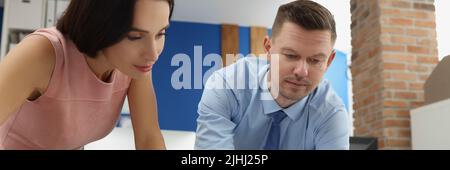 I lavoratori aziendali intelligenti impegnati esaminano i documenti statistici sul luogo di lavoro Foto Stock