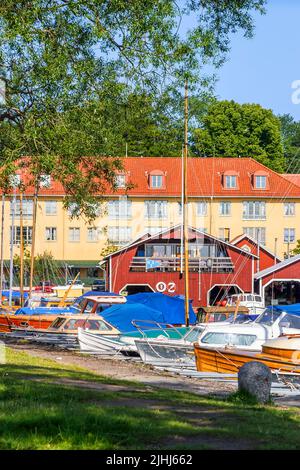 Barche e case nel porto di Hjo, Svezia Foto Stock