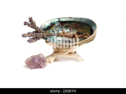 Guscio di abalone con Bundle di lavanda e pietra di Ametista per la pulizia e la purificazione isolato su sfondo bianco Foto Stock