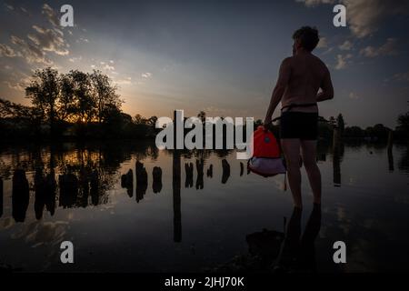 Henley on Thames, Regno Unito. 19th luglio 2022. In quello che potrebbe rivelarsi il giorno registrato più caldo del Regno Unito, un nuotatore all'aperto fa una nuotata rinfrescante nel fiume Tamigi vicino a Henley sul Tamigi all'alba. Allan Staley/Alamy Live News Foto Stock