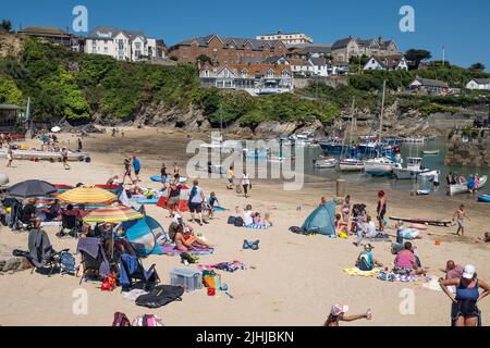 I turisti si godono il sole glorioso su una staycation nel pittoresco porto di Newquay in Cornovaglia in Inghilterra nel Regno Unito. Foto Stock