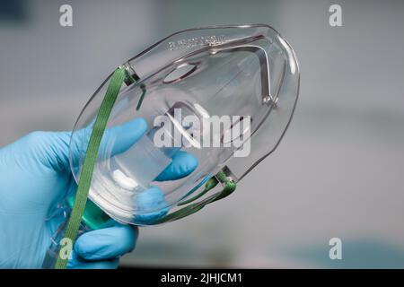 Mano del medico con il supporto di respirazione di pur della maschera di ossigeno usa e getta Foto Stock