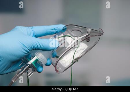 Mano del medico con il supporto di respirazione di pur della maschera di ossigeno usa e getta Foto Stock