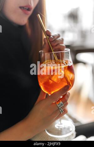 Donna che beve aperol spritz cocktail Foto Stock