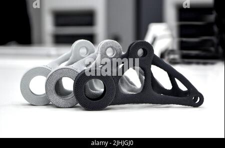 Modelli in grigio bianco e nero stampati su stampante 3D in laboratorio. Oggetti stampati su stampante 3D in plastica. Prototipi realizzati con stampante 3D. Nuova tecnologia di stampa moderna. Multi Jet Fusion Foto Stock