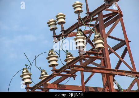 Vecchia colonna di cemento stradale con parte di ferro arrugginita in cima e tagliare i fili. Installazione o smontaggio dell'elettricità. Polo di energia rotto. Foto Stock