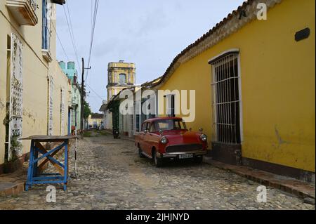 Auto d'epoca rossa sulle strade acciottolate di Trinidad, Cuba. Foto Stock