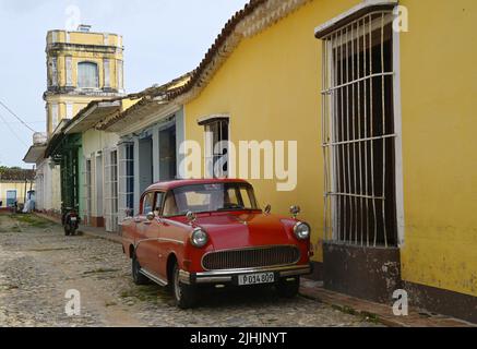 Auto d'epoca rossa sulle strade acciottolate di Trinidad, Cuba. Foto Stock