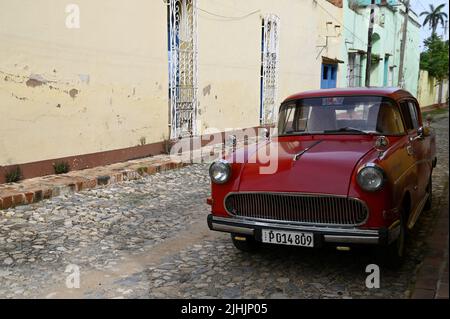 Auto d'epoca rossa sulle strade acciottolate di Trinidad, Cuba. Foto Stock