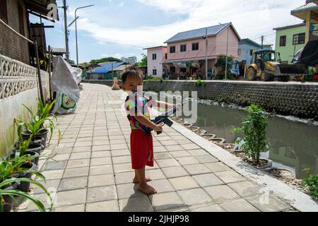 Chiang mai, Tailandia. 18th luglio 2022. Un bambino gioca con un giocattolo pistola al canale Khlong Mae Kha a Chiang mai. Il progetto prevede la costruzione di pavimentazioni, la creazione di un sistema di gestione delle acque reflue e il miglioramento del paesaggio. Il paesaggio urbano lungo sarà una nuova strada pedonale lungo il comune di Chiang mai. Credit: SOPA Images Limited/Alamy Live News Foto Stock