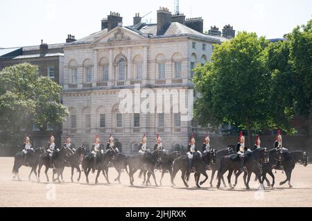 I membri della Household Cavalry si buttano in polvere mentre attraversano la Horse Guards Parade, Londra, mentre i britannici sono impostati per vivere la giornata più calda del Regno Unito, mentre si prevede che le temperature raggiungeranno il 40C. Data foto: Martedì 19 luglio 2022. Foto Stock