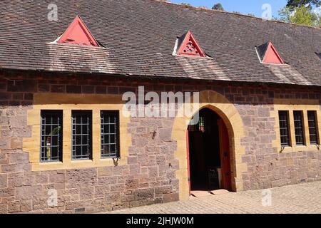 La porta ad arco nel centro visitatori di una casa di campagna inglese. Sono stalle convertite intorno ad un grande cortile Foto Stock