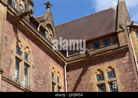 Guardando in su a due gargoyles su una casa di campagna inglese Foto Stock