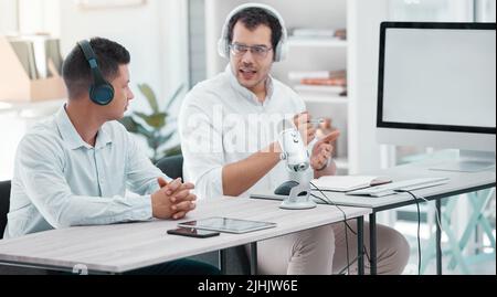 Due giovani che fanno una trasmissione in un ufficio. Foto Stock