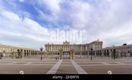 La facciata principale del palazzo reale di Madrid con la sua enorme spianata e il cielo blu con le nuvole all'alba. Spagna. Foto Stock