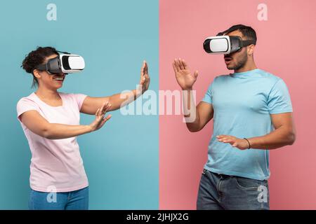 Giovani sposi neri in visore VR che toccano l'aria durante l'esperienza di realtà virtuale, sfondo blu e rosa dello studio Foto Stock