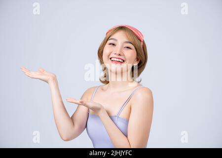 Giovane bella donna che indossa maschera di sonno e pajama, sorridente allegro presentando su sfondo bianco Foto Stock