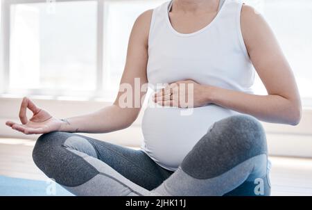Godendo la mia gravidanza. Una donna incinta che fa yoga a casa. Foto Stock