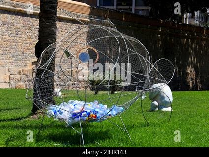 Cartagena, Murcia, Spagna- 17 luglio 2022: Struttura in ferro a forma di pesce per riciclare contenitori di plastica sulla strada Foto Stock