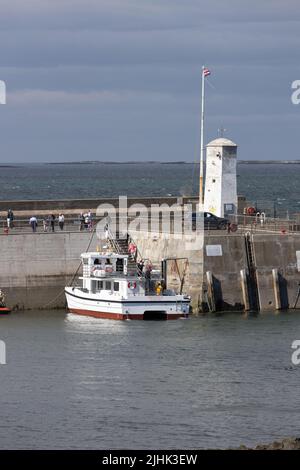 I passeggeri sbarcano da Serenity 3 Farne Islands Pleasure Boat Trips al porto di Seahouses Northumberland Inghilterra Gran Bretagna Foto Stock