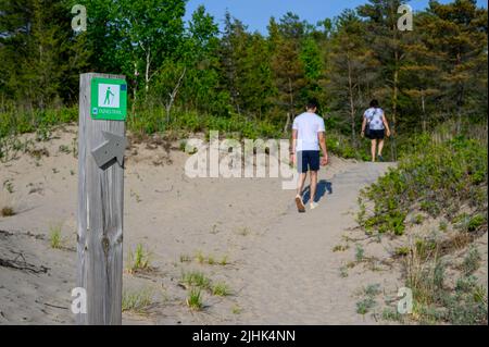 Madre e figlio di discendenza indiana e gara mista camminano lungo il Dunes Trail a Sandbanks Dunes Beach, Prince Edward County, Ontario, Canada. Foto Stock